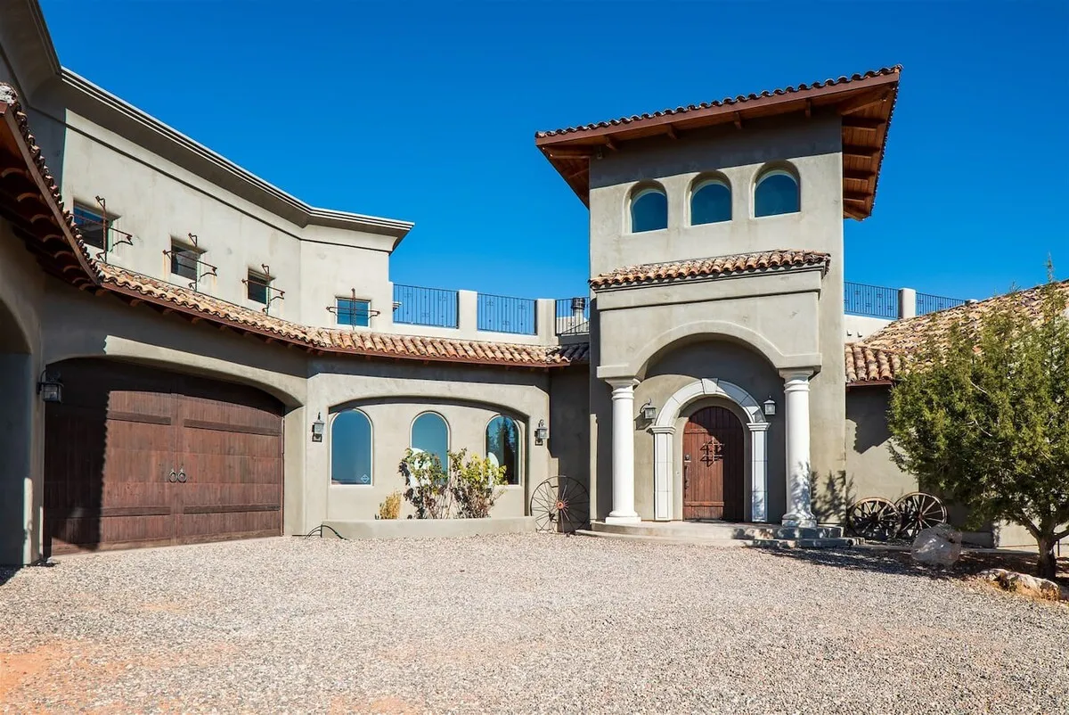 This exterior image captures the main entrance of the property, showcasing decorative windows, a tower structure, and lush landscaping. The welcoming architecture and inviting surroundings set the tone for special occasions and group celebrations.